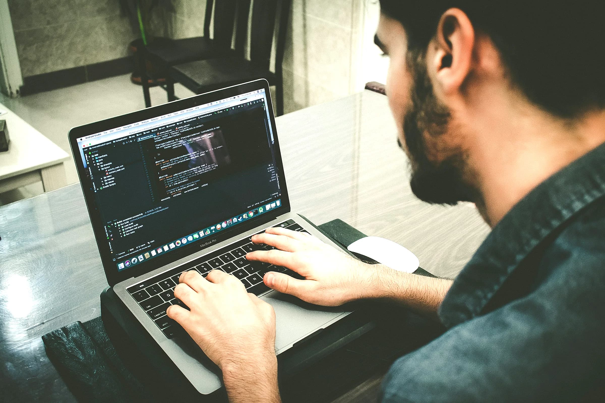 A developer programming on a laptop at a cafe table